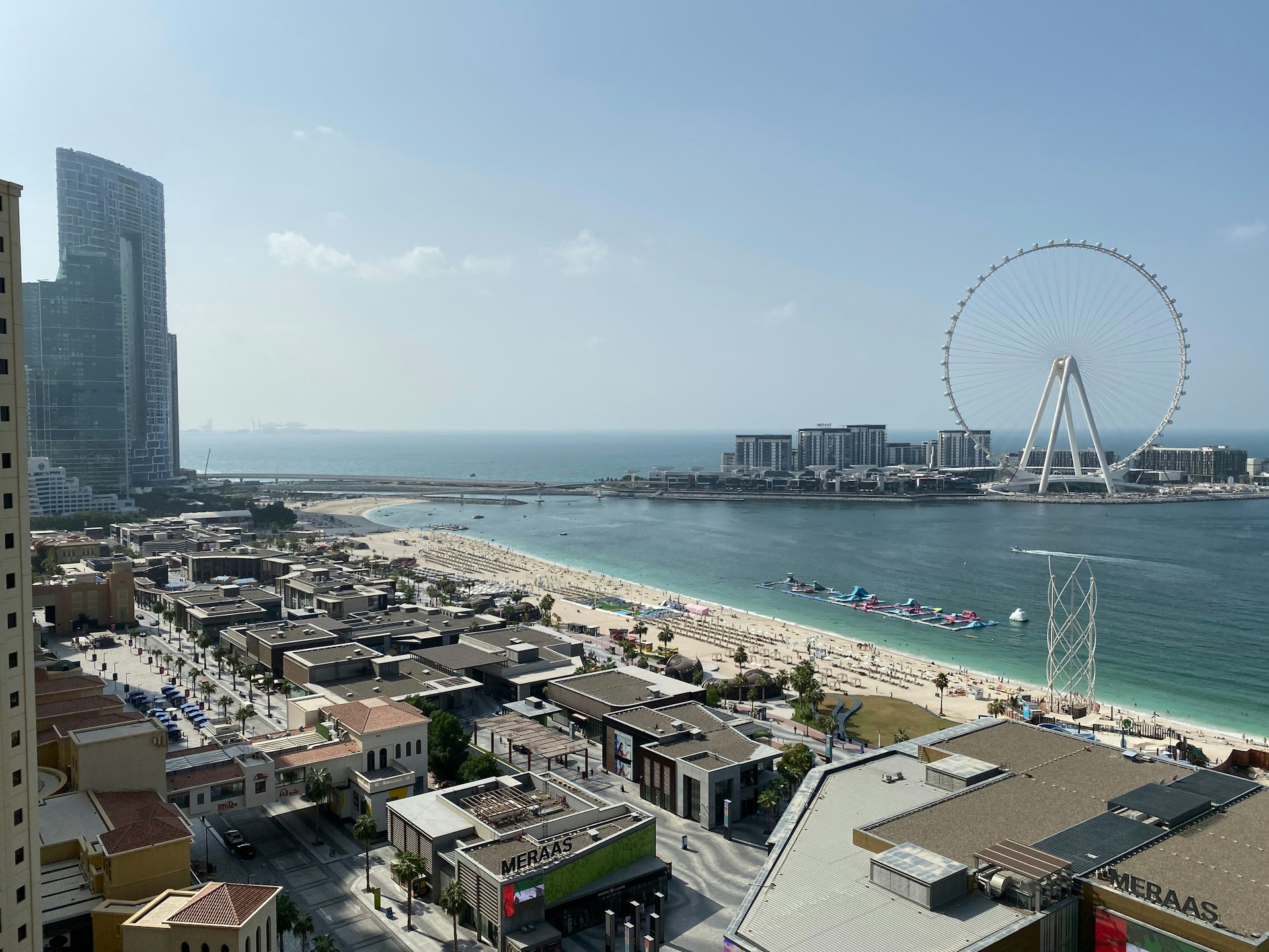 a view of a beach with a ferris wheel in the distance